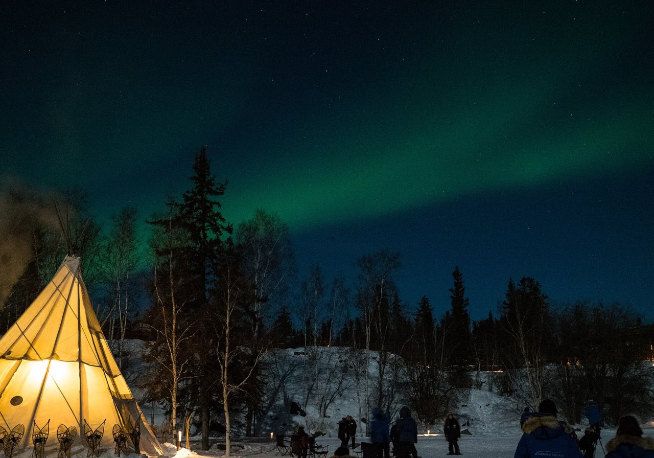 Snowshoer crossing a frozen lake near Yellowknife at sunset